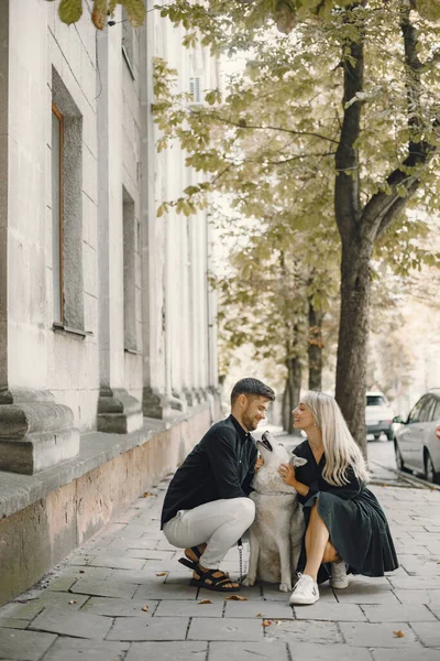Jong stijlvol paar wandelen met hond in straat — Stockfoto