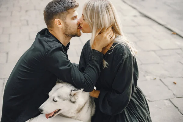 Young stylish couple walking with dog in street — Stock Photo, Image