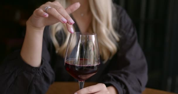 Charmante jonge vrouw aanraken van de rand van een wijnglas — Stockvideo