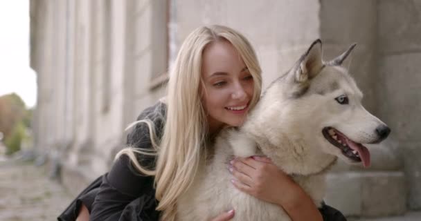 快乐的年轻女人在外面抱着她的狗 — 图库视频影像