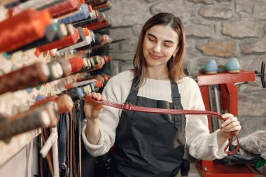 Kadın terzi dikiş ve nakış için renkli iplik makaraları seçiyor.