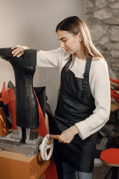 Женщина-ремесленница по коже чинит обувь — стоковое фото