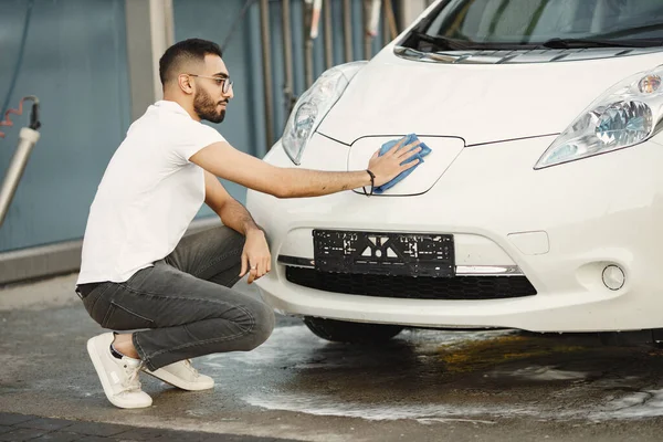 Pria India menyeka transportasi putihnya pada pencucian mobil setelah mencuci — Stok Foto