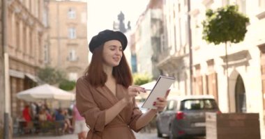 Sokakta elinde defteriyle gezen bir sanatçı kız.