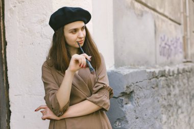 Elinde boya fırçası olan siyah şapkalı bir kız.