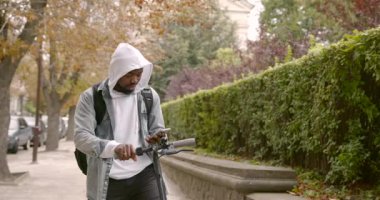 Elektrikli scooter 'da duran siyah bir adam.