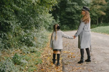 Sonbahar parkında şirin ve şık bir aile.