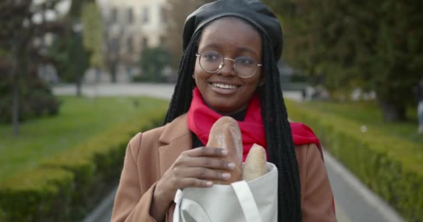 Junges schwarzes Mädchen mit Baskenmütze und Baguette in der Hand — Stockvideo