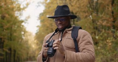 Kameralı gezgin, sonbahar ormanının fotoğraflarını çekiyor.