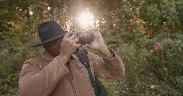 Ein junger schwarzer Reisender filmt den Wald vor laufender Kamera — Stockvideo