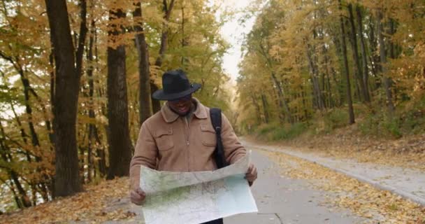 Viajero negro joven con un mapa en las manos — Vídeos de Stock