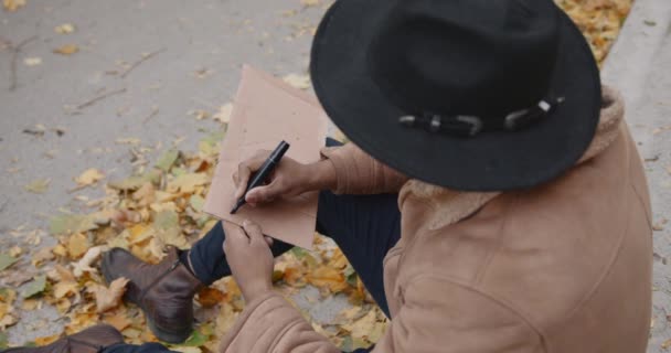 Mladý černý stopař psaní na kartonu na silnici — Stock video