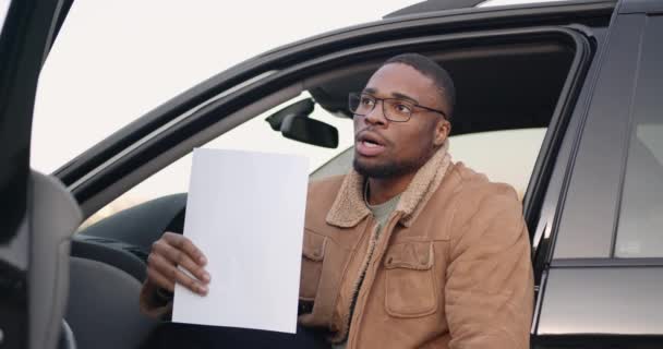 Conducteur masculin au volant avec feuille de papier — Video