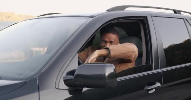 Enojado conductor negro detrás del volante de un coche — Vídeos de Stock