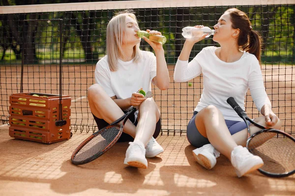 Ženy přátelé mají odpočinek po tenisovém zápase — Stock fotografie