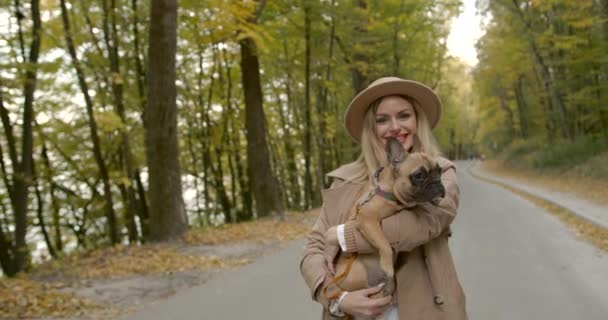 Glückliche stilvolle Frau mit Haustier im Arm unterwegs — Stockvideo