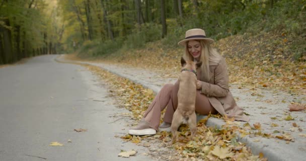 一个抱着宠物坐在小巷边上的女人 — 图库视频影像