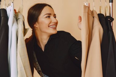 Stüdyoda bir sürü kıyafeti olan bir kadın.