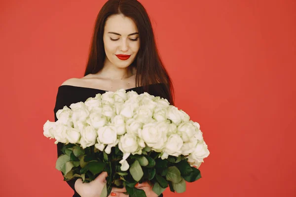 Žena v černých šatech s kyticí růží — Stock fotografie