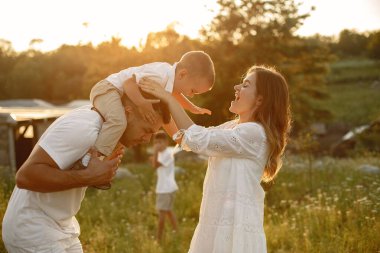 Yaz tarlasında oynayan sevimli bir aile.