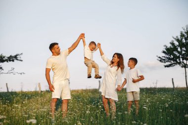 Yaz tarlasında oynayan sevimli bir aile.