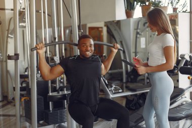 Yakışıklı siyah adam beyaz koçla antrenman yapıyor.