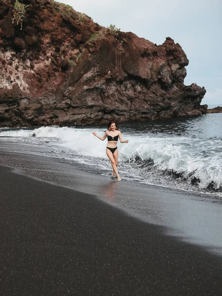 Flicka i en snygg baddräkt har en vila n en strand — Stockfoto