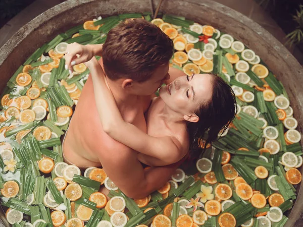 Pareja se encuentra en un baño redondo con frutas —  Fotos de Stock