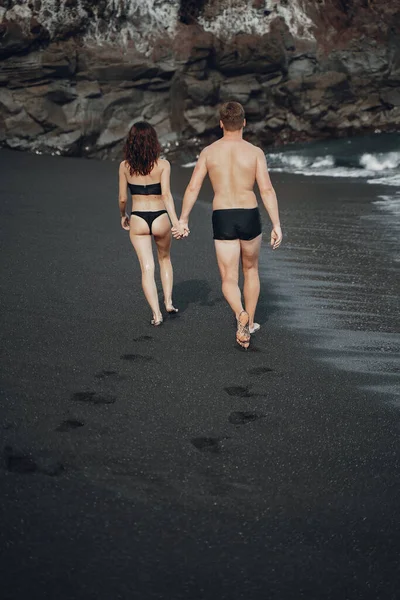 Elegante pareja en una playa cerca de las rocas —  Fotos de Stock