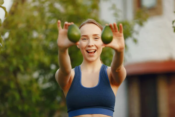 Spor elbiseli bir kadın meyve tutuyor. — Stok fotoğraf