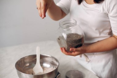 Beyaz elbiseli şef çikolatalı pasta hazırlıyor..