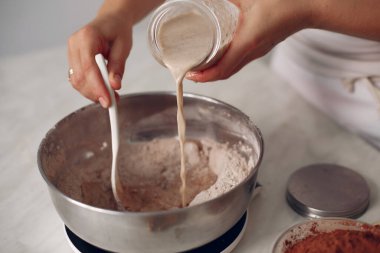 Beyaz elbiseli şef çikolatalı pasta hazırlıyor..