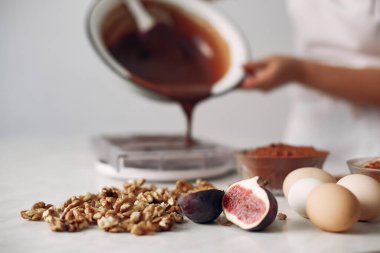 Beyaz elbiseli şef çikolatalı pasta hazırlıyor..