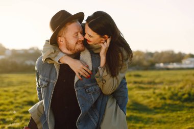 Tarlada yürüyüp poz veren şık romantik bir çift.