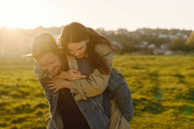 Tarlada yürüyüp poz veren şık romantik bir çift.
