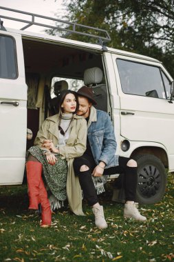 Eski bir otobüste oturan şık bir çift fotoğraf için poz veriyor.