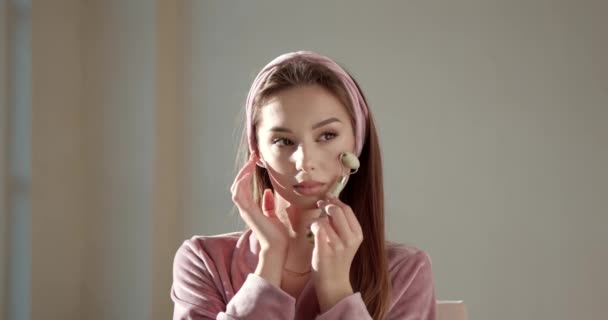 Mujer usando rodillo facial de jade para masaje facial en casa — Vídeos de Stock