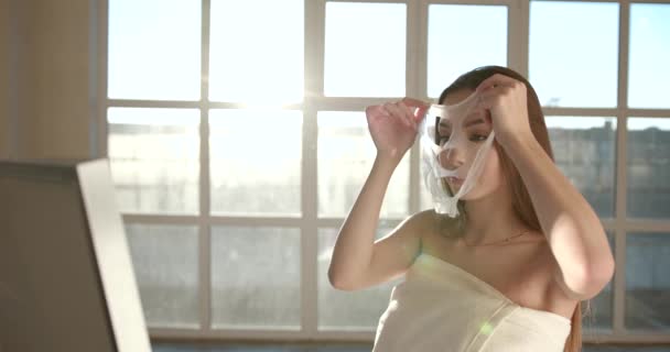 Mujer joven que aplica máscara cosmética en la cara — Vídeos de Stock