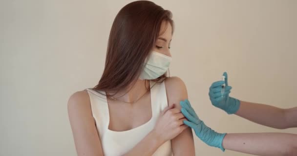 Menina em uma máscara recebendo injeção em fundo bege — Vídeo de Stock