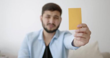 Genç bir Hint futbol fanatiği evde televizyon izliyor.