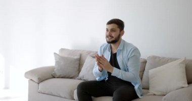 Genç bir Hint futbol fanatiği evde televizyon izliyor.
