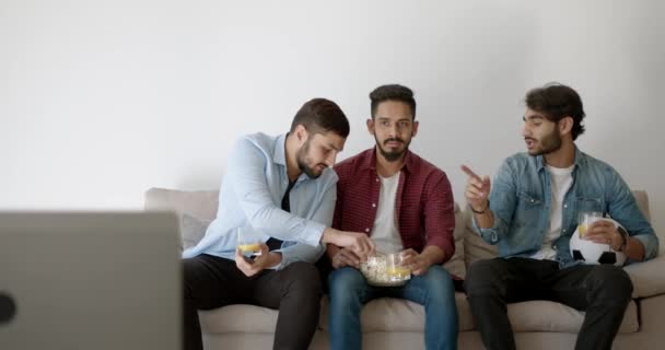 Three Indian young men watching football at home — Video Stock