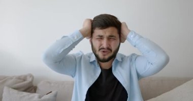 Genç bir Hint futbol fanatiği evde televizyon izliyor.