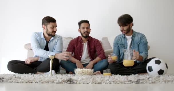 Three Indian young men watching football at home — Video Stock