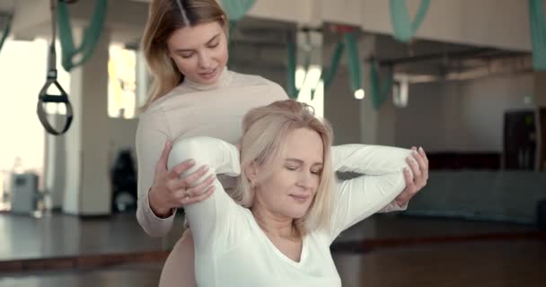 Treinador feliz ajudando a mulher grávida fazendo exercícios de alongamento — Vídeo de Stock