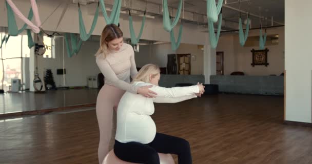 Mulher grávida e seu personal trainer fazendo exercícios de alongamento — Vídeo de Stock
