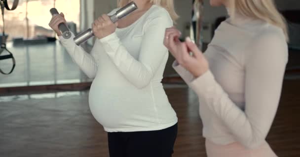 Pregnant women doing fitness exercise with dumbbells — Wideo stockowe