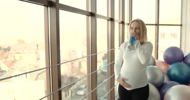 Pregnant woman drinking water in the gym — Stock Video