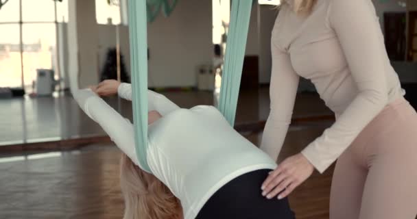 Беременная женщина занимается аэройогой с личным тренером — стоковое видео