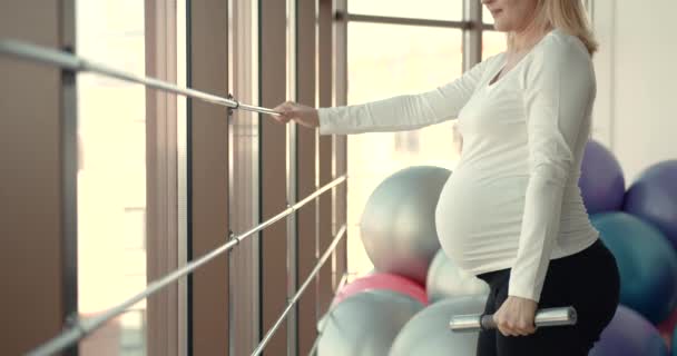 A pregnant woman doing bicep muscle exercises — Wideo stockowe